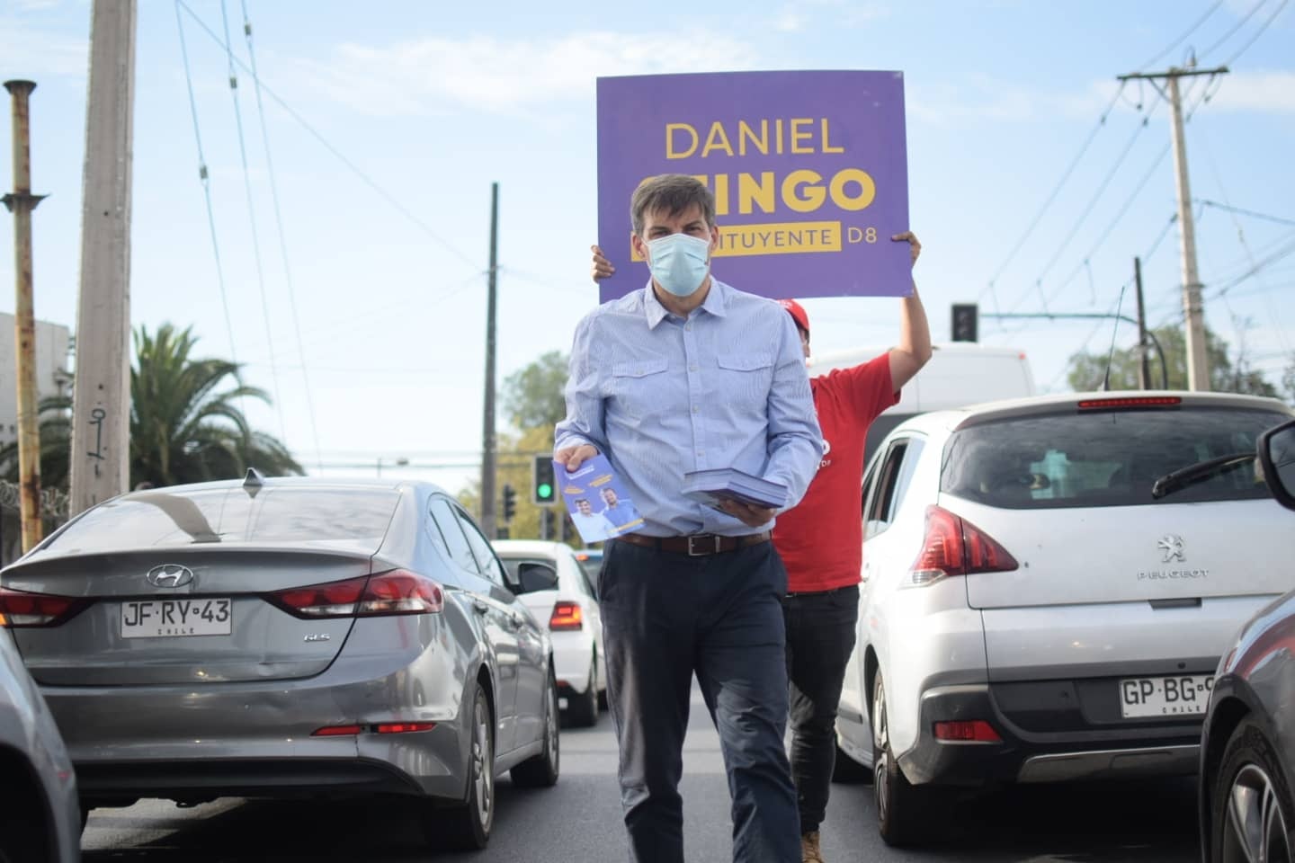 Daniel Stingo reparte volantes durante su campaña frente a un semáforo.