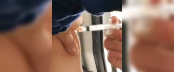 Joven vacunada con jeringa vacía en Espacio Riesco