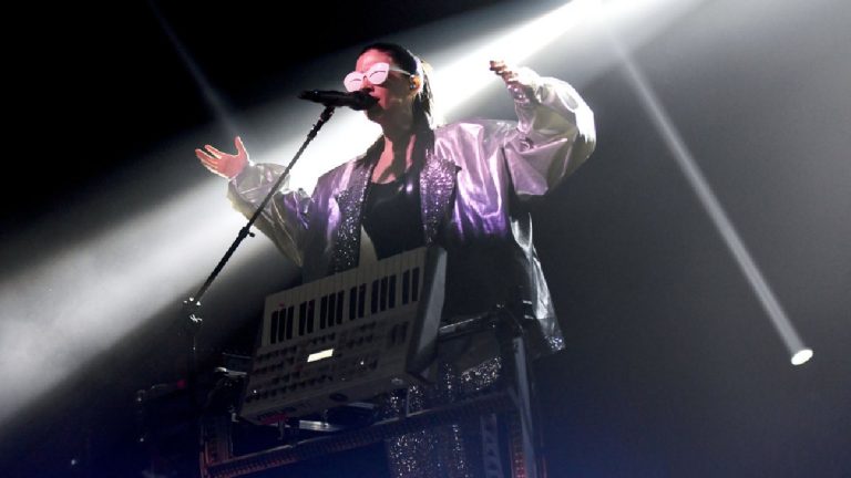 Javiera Mena vestida de color plata en un concierto en vivo