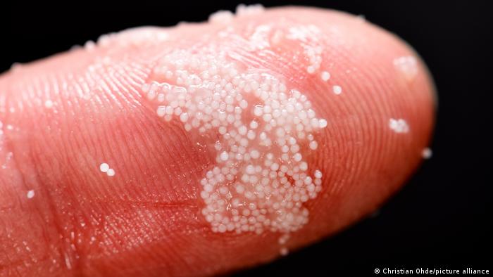 Partículas de microplástico en un dedo.