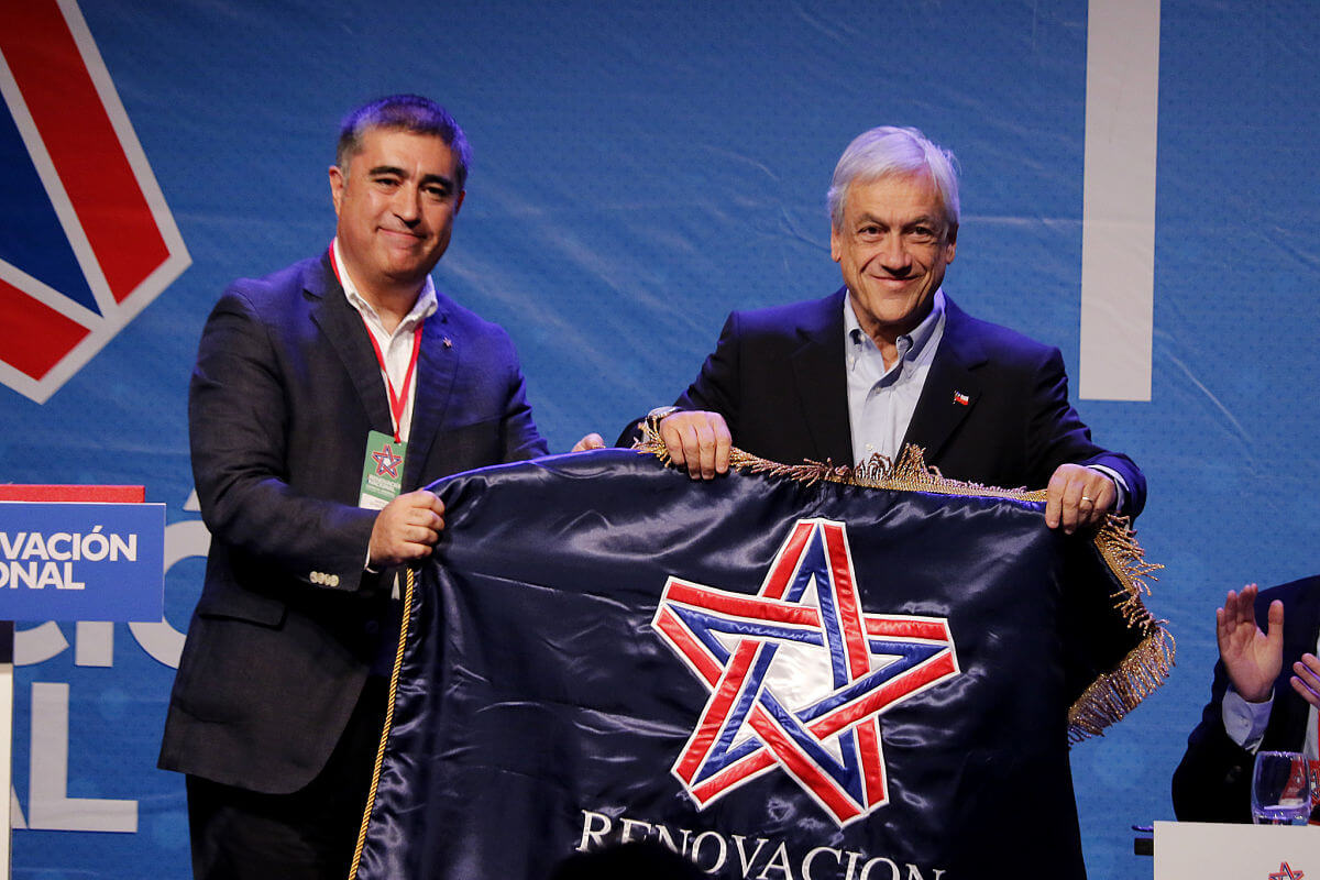 Mario Desbordes y Sebastián Piñera sosteniendo la bandera de Renovación Nacional en 2018