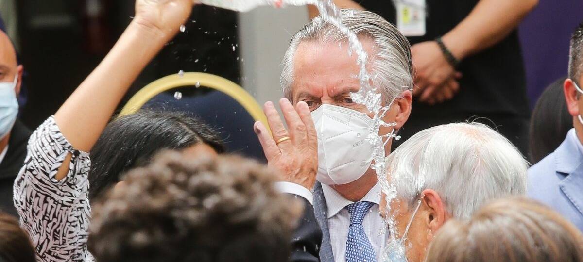 Audrey Burgos lanza agua al Presidente Sebastián Piñera luego de concluir la ceremonia de conmemoración de dos años del primer caso de Covid-19 en Chile.