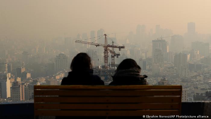 Gente mira el horizonte a través del aire contaminado, en la zona montañosa de Velenjak, en Teherán, Irán.