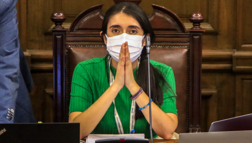 Maria Elisa Quinteros, sentada en el Pleno de la Convención Constitucional con sus codos apoyados en la mesa y sus manos juntas, como si estuviese rezando