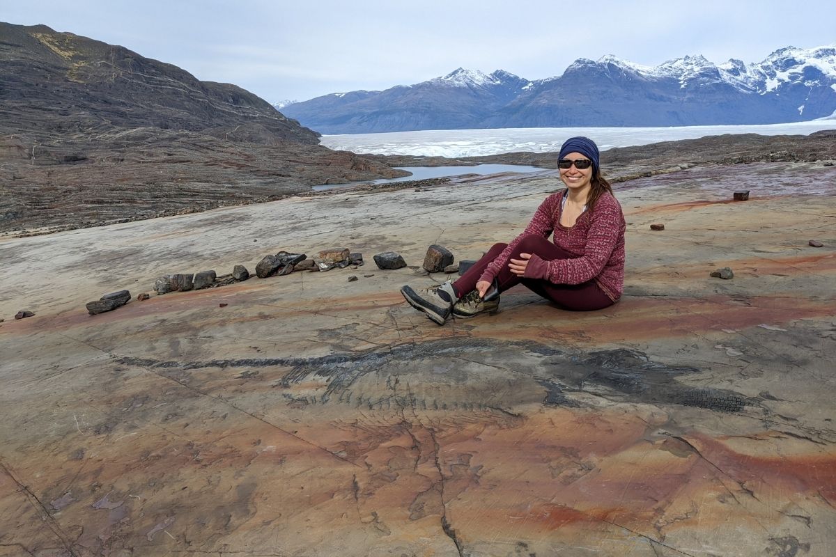 La paleontóloga Judith Pardo Pérez posa al lado del fósil del Fiona, el ictiosaurio recuperado en la Patagonia.