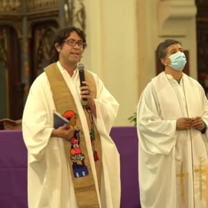 sacerdote Nicolás Viel sosteniendo el micrófono en la misa por el fallecimeinto del sacerdote Matías valenzuela