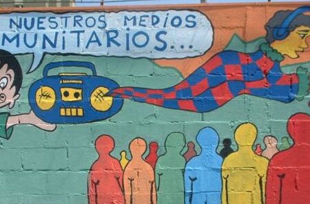 La imagen muestra un mural alusivo a medios comunitarios