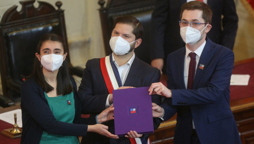Maria Elisa Quinteros, Gabriel Boric y Gaspar Domínguez sosteniendo el texto de nueva Constitución