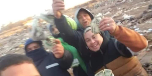 Argentinos mostrando los dólares que hallaron en el basurero