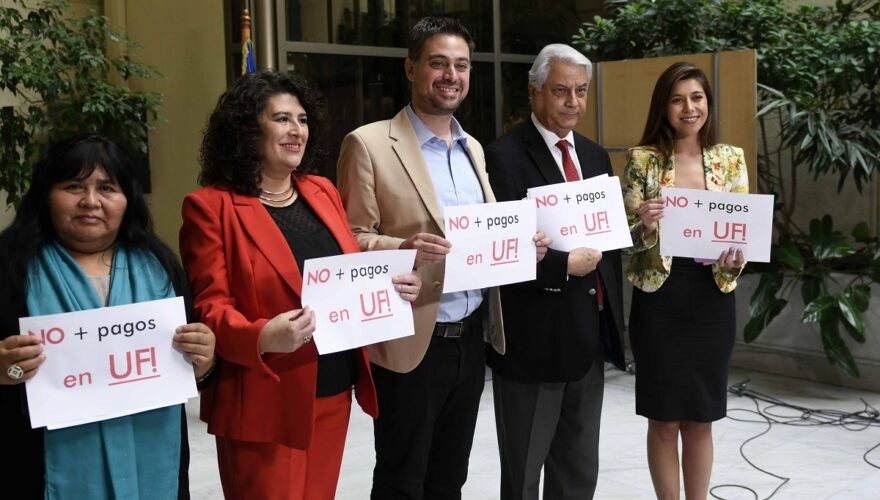 Parlamentarios del Partido Socialista sostienen letreros con el mensaje "No más pagos en UF".