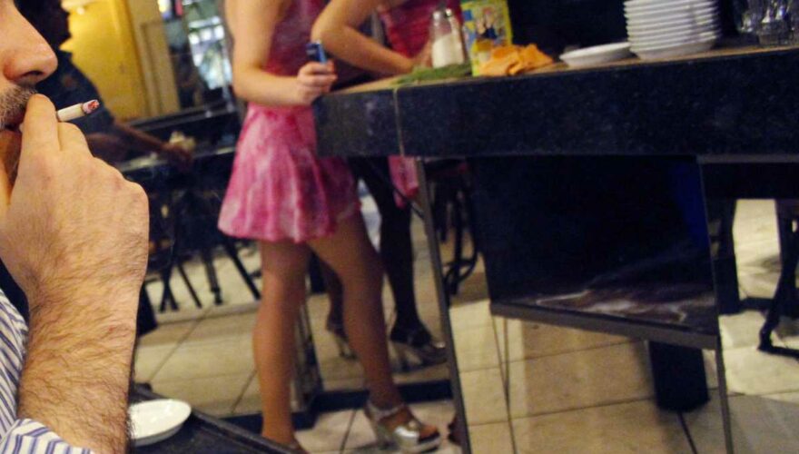 Dos meseras de un café con piernas caminando en un vestido corto.