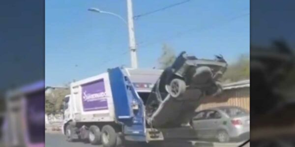 Camión recolector de basura de la Municipalidad de San Bernardo llevándose un automóvil en su interior