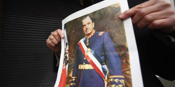 Persona tomando fotografía de Augusto Pinochet Ugarte, cuya arma fue incautada a un joven de 15 años de Valdivia por la PDI
