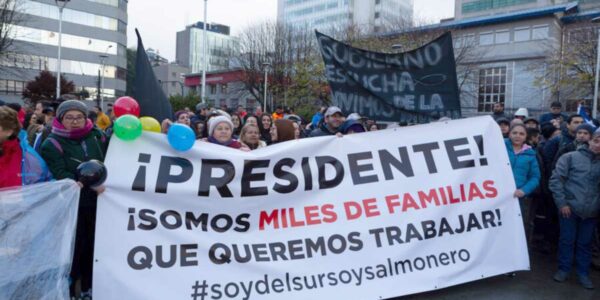 Salmoneros marchan en contra de proyecto para áreas protegidas en Puerto Montt. Pancarta interpela al Presidente Boric.