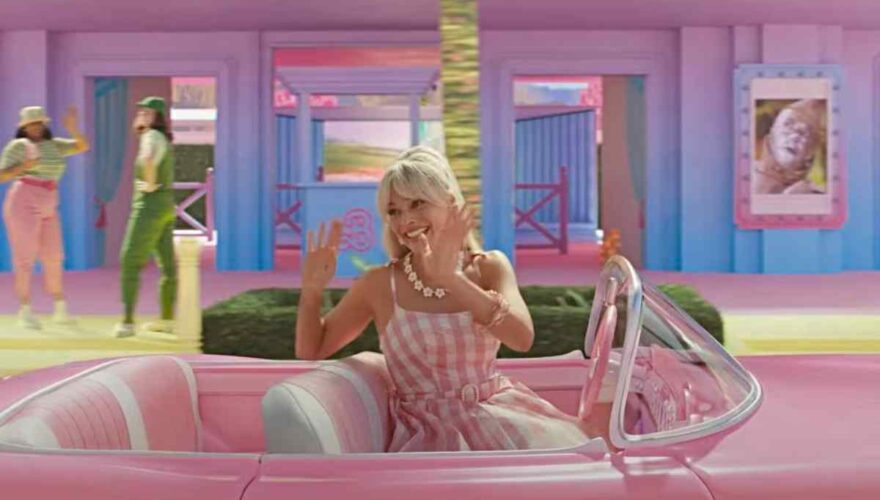 Margot Robbie en un auto rosado por Barbie La Película