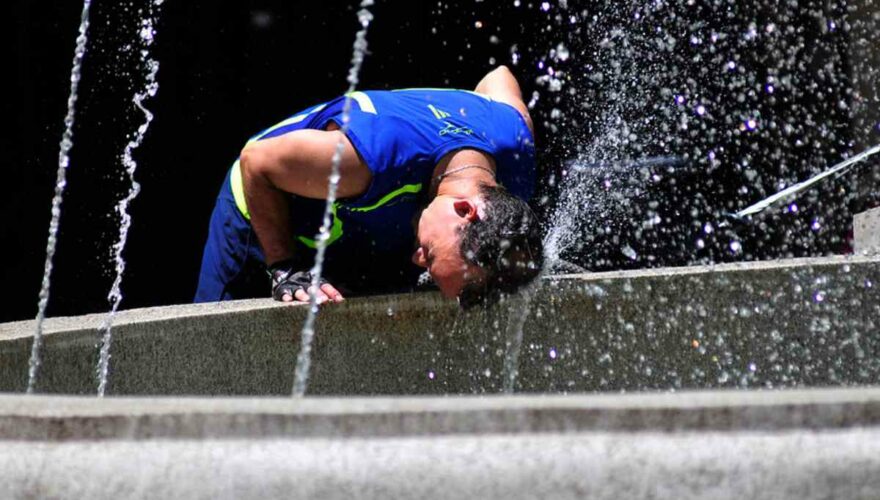 Hombre refrescándose en una ola de calor de verano en Santiago
