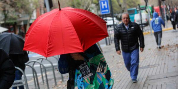 Mujer con paraguas por lluvia en Santiago