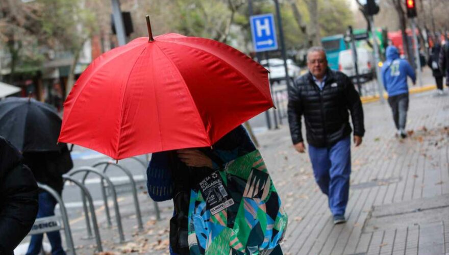 Mujer con paraguas por lluvia en Santiago