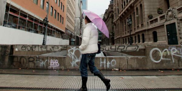 Mujer camina por la lluvia en Santiago