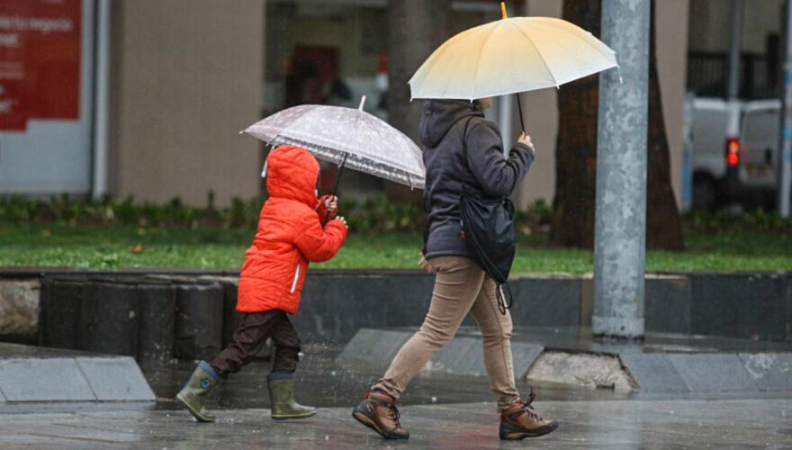 Mujer y niño caminando por la lluvia en Santiago