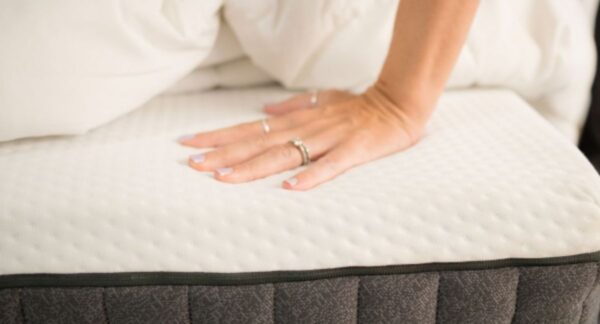 Mujer tocando colchón para no cometer errores al dormir.