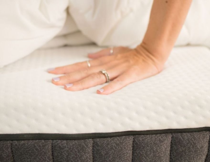 Mujer tocando colchón para no cometer errores al dormir.
