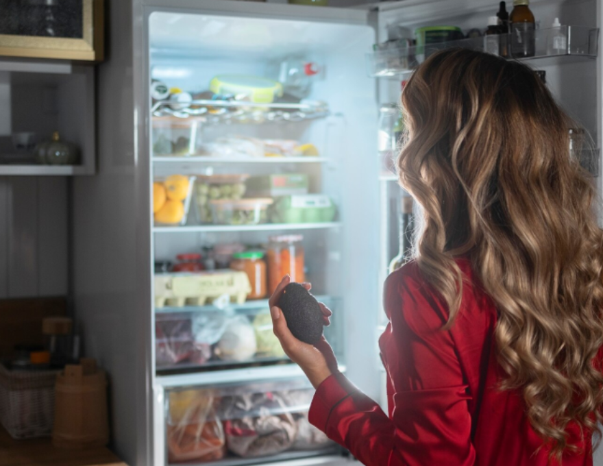 Mujer abriendo un refrigerador que compró en el Cyberday 2025.
