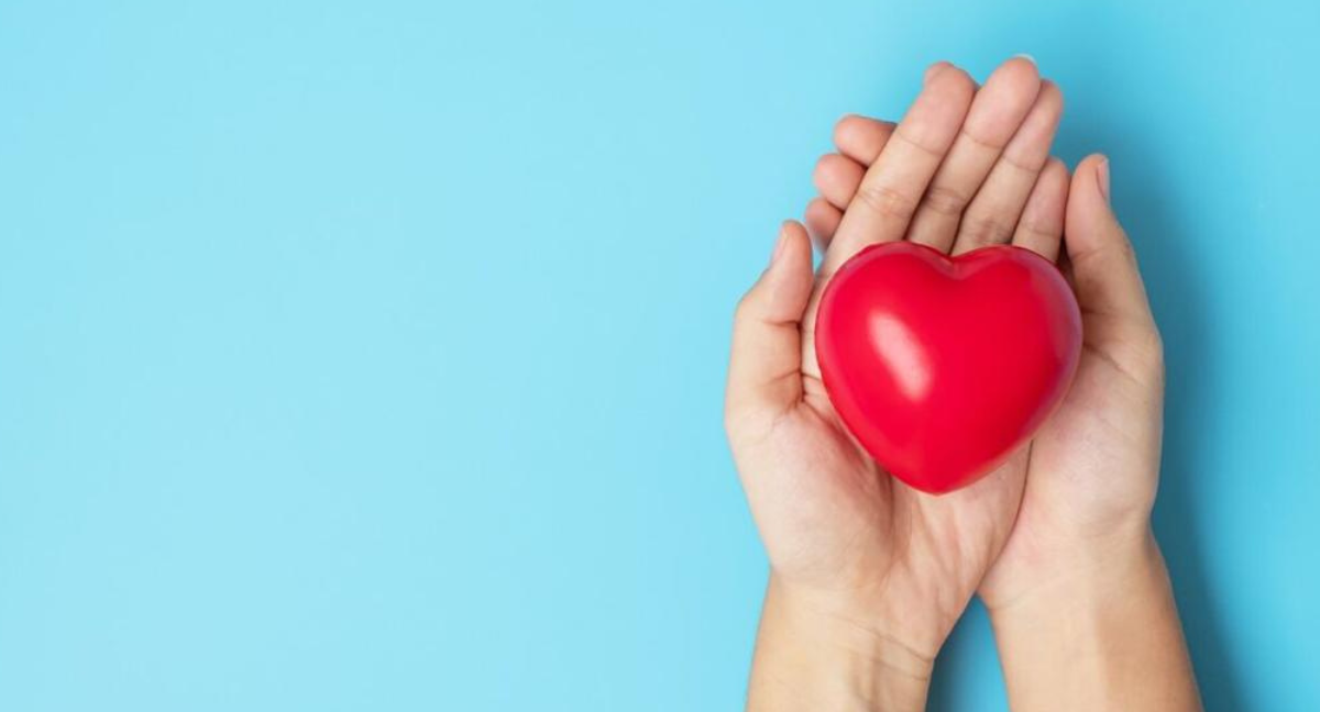 Foto de una mujer sosteniendo un corazón para prevenir los riesgos cardiovasculares en mujeres.