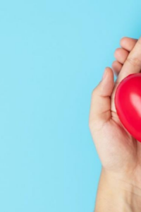 Foto de una mujer sosteniendo un corazón para prevenir los riesgos cardiovasculares en mujeres.