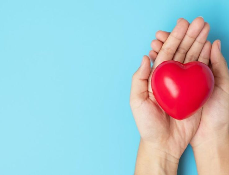 Foto de una mujer sosteniendo un corazón para prevenir los riesgos cardiovasculares en mujeres.