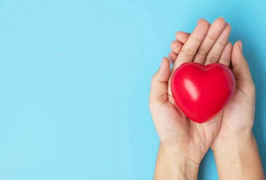 Foto de una mujer sosteniendo un corazón para prevenir los riesgos cardiovasculares en mujeres.