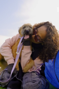 Personas en el evento de Movicenter y Supergirl adoptando perros.