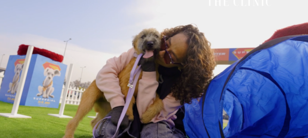 Personas en el evento de Movicenter y Supergirl adoptando perros.