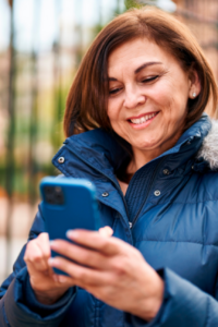 Mujer usando tecnología de BancoEstado para sacar su cupón de gas licuado.